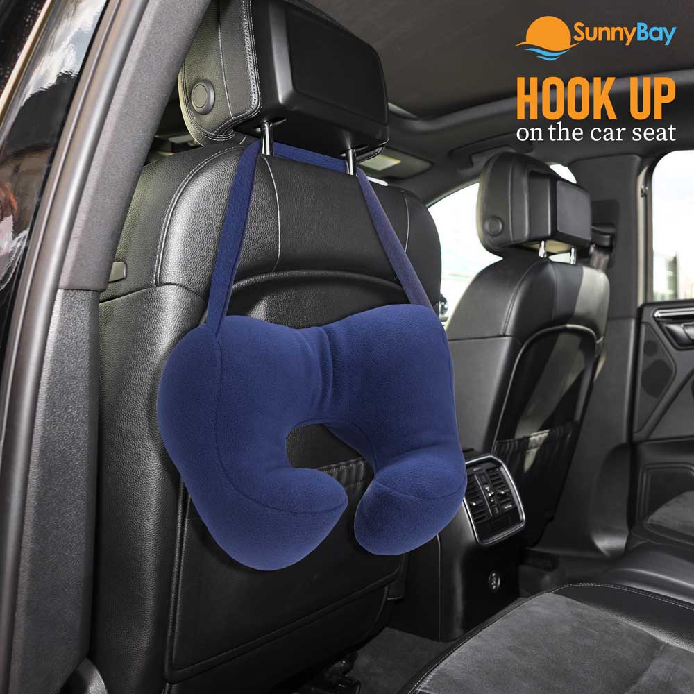 Blue travel pillow hangs on a car seat headrest.